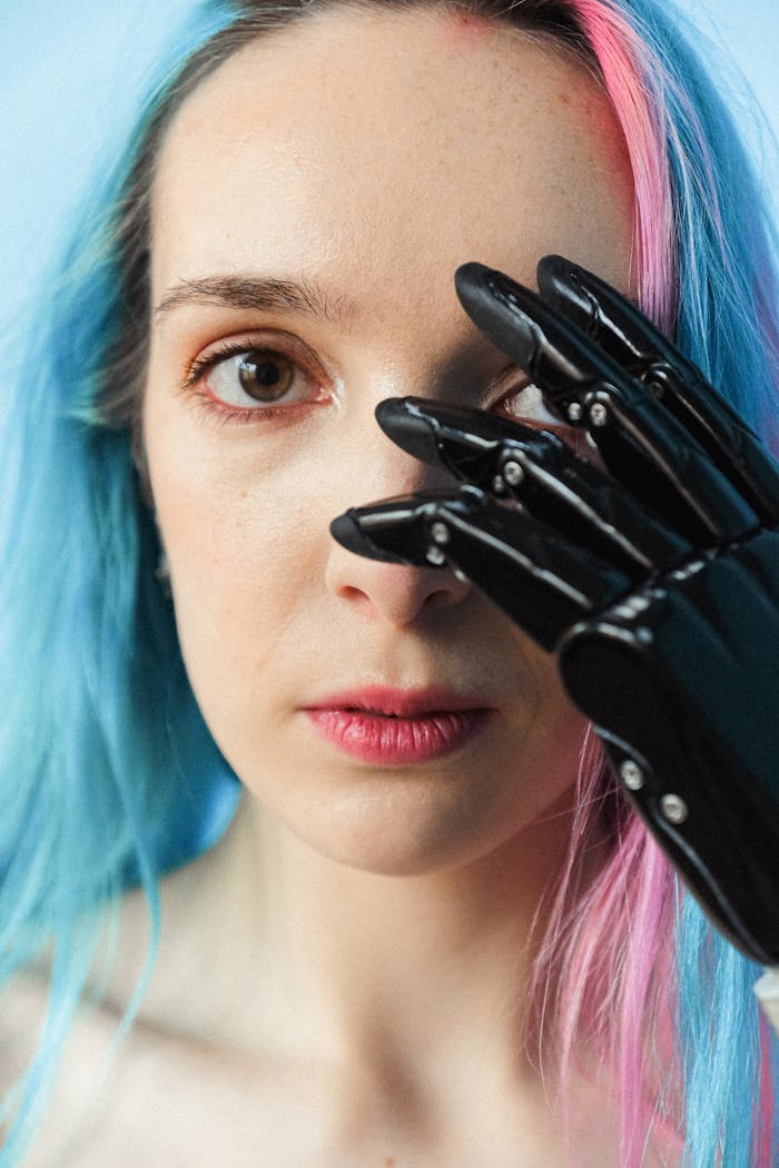 Close-up portrait of a woman with colored hair and a prosthetic hand